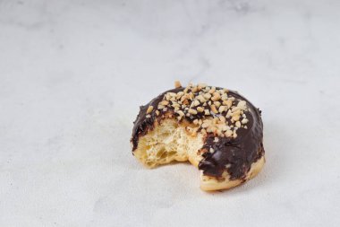 Masada servis edilen fındıklı fındıklı tatlı çikolatalı donut konsepti. Beyaz arkaplanda izole edilmiş resim