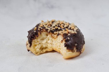 Masada servis edilen fındıklı fındıklı tatlı çikolatalı donut konsepti. Beyaz arkaplanda izole edilmiş resim