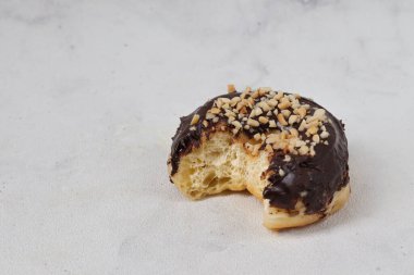 Masada servis edilen fındıklı fındıklı tatlı çikolatalı donut konsepti. Beyaz arkaplanda izole edilmiş resim