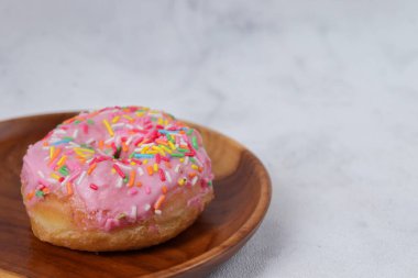 Tahta tabakta servis edilen lezzetli, tatlı, pembe çilekli çörekler. Beyaz arkaplanda izole edilmiş resim