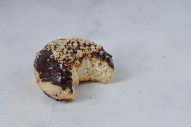 Masada servis edilen fındıklı fındıklı tatlı çikolatalı donut konsepti. Beyaz arkaplanda izole edilmiş resim