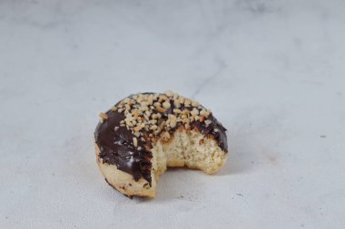 Masada servis edilen fındıklı fındıklı tatlı çikolatalı donut konsepti. Beyaz arkaplanda izole edilmiş resim