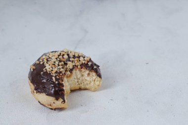Masada servis edilen fındıklı fındıklı tatlı çikolatalı donut konsepti. Beyaz arkaplanda izole edilmiş resim