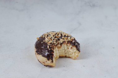 Masada servis edilen fındıklı fındıklı tatlı çikolatalı donut konsepti. Beyaz arkaplanda izole edilmiş resim