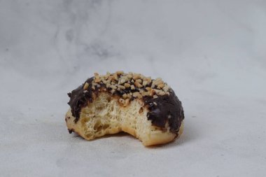 Masada servis edilen fındıklı fındıklı tatlı çikolatalı donut konsepti. Beyaz arkaplanda izole edilmiş resim