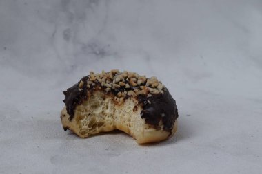 Masada servis edilen fındıklı fındıklı tatlı çikolatalı donut konsepti. Beyaz arkaplanda izole edilmiş resim