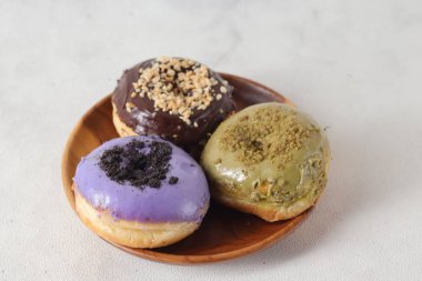 Masada farklı tatlar bulunan lezzetli çörekler. Beyaz arkaplanda izole edilmiş resim