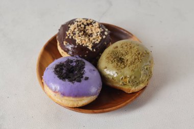 Masada farklı tatlar bulunan lezzetli çörekler. Beyaz arkaplanda izole edilmiş resim