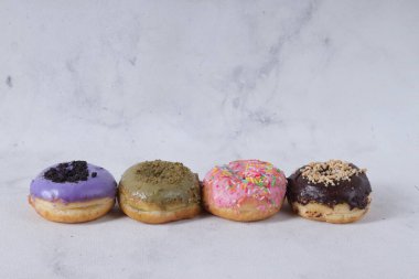 Masada farklı tatlar bulunan lezzetli çörekler. Beyaz arkaplanda izole edilmiş resim