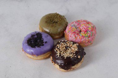 Masada farklı tatlar bulunan lezzetli çörekler. Beyaz arkaplanda izole edilmiş resim