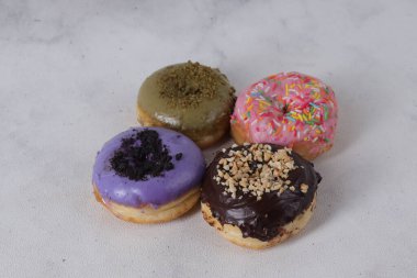 Masada farklı tatlar bulunan lezzetli çörekler. Beyaz arkaplanda izole edilmiş resim