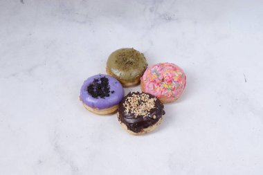 Masada farklı tatlar bulunan lezzetli çörekler. Beyaz arkaplanda izole edilmiş resim