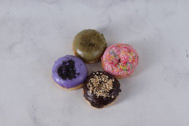 Masada farklı tatlar bulunan lezzetli çörekler. Beyaz arkaplanda izole edilmiş resim