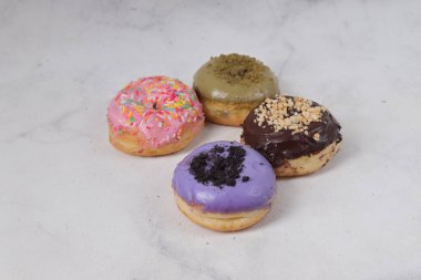 Masada farklı tatlar bulunan lezzetli çörekler. Beyaz arkaplanda izole edilmiş resim