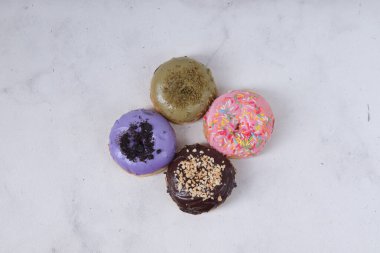 Masada farklı tatlar bulunan lezzetli çörekler. Beyaz arkaplanda izole edilmiş resim