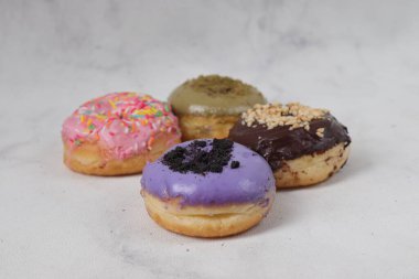Masada farklı tatlar bulunan lezzetli çörekler. Beyaz arkaplanda izole edilmiş resim
