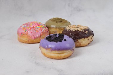 Masada farklı tatlar bulunan lezzetli çörekler. Beyaz arkaplanda izole edilmiş resim