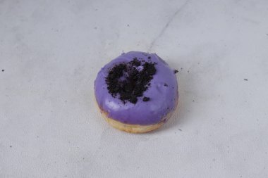 Masanın üzerine çikolata parçacıkları serpiştirilmiş lezzetli mor jöleli çöreğin düz manzarası. Beyaz arkaplanda izole edilmiş resim