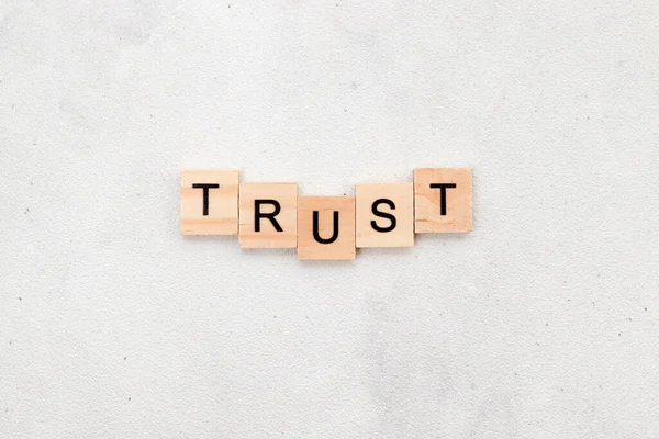 ホワイトバックグラウンドの木製キューブ文字ブロック上の信頼の単語のトップビュー ビジネスコンセプト — ストック写真
