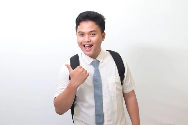 印尼高中学生穿着白色衬衫制服 灰色领带显示产品 指着什么 微笑着 白色背景上的孤立图像 — 图库照片