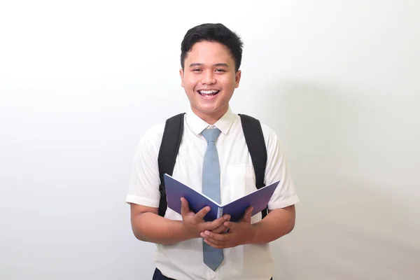 Indonezyjski Uczeń Białej Koszuli Szarym Krawatem Trzymający Notatnik Uśmiechający Się — Zdjęcie stockowe