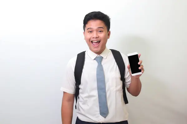 印尼高中学生身穿白衬衫制服 灰色领带 展示和展示空白屏幕手机 白色背景上的孤立图像 — 图库照片
