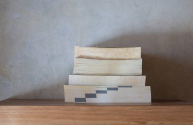 Yüzen ahşap kitaplığın üzerinde bir yığın sarımsı ve antika kitap. Eğitim ve bilgi kavramı. Okuyacak kitap yığını