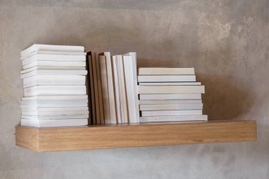 Yüzen ahşap kitaplıkta yığınla kitap. Eğitim ve bilgi kavramı. Okuyacak bir yığın kitap. Evin iç dekorasyonu