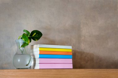 Yüzen ahşap kitaplıkta renkli kitaplar yığını. Eğitim ve bilgi kavramı. Okuyacak bir yığın kitap. Evin iç dekorasyonu