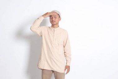 Beyaz gömlekli, migreni olan, şakağına dokunan Asyalı Müslüman adamın portresi. Baş ağrısı hastalığı konsepti. Beyaz arkaplanda izole edilmiş resim