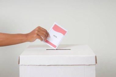 Elle yerleştirmeyi kapat ve oy pusulasını oy sandığına koy. Endonezya cumhurbaşkanı ve hükümeti için genel seçimler veya Pemilu. Beyaz arkaplanda izole edilmiş resim