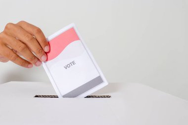 Elle yerleştirmeyi kapat ve oy pusulasını oy sandığına koy. Endonezya cumhurbaşkanı ve hükümeti için genel seçimler veya Pemilu. Beyaz arkaplanda izole edilmiş resim