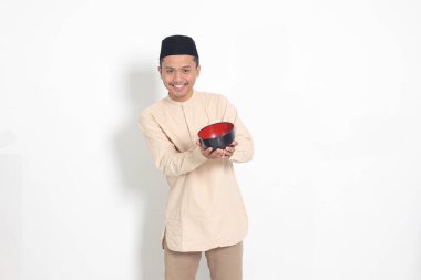 Koko gömlekli heyecanlı Asyalı Müslüman adamın portresi. Kafatası açık ve elinde boş bir tabak var. Gıda markası için kase şablonu. Beyaz arkaplanda izole