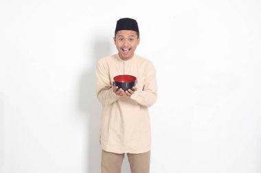 Koko gömlekli heyecanlı Asyalı Müslüman adamın portresi. Kafatası açık ve elinde boş bir tabak var. Gıda markası için kase şablonu. Beyaz arkaplanda izole