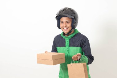 Yeşil ceket ve kask giyen Asyalı kurye sürücüsü portresi. Müşteri için paket ve kutu teslimatı. Beyaz arkaplanda izole edilmiş resim