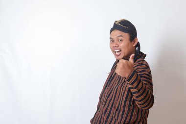 Cava kumaşlı, beyaz şapkalı, onay ve anlaşma işareti gösteren, el hareketi yapan Asyalı bir adamın portresi. Beyaz arkaplanda izole edilmiş resim