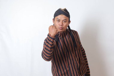 Beyaz şapkalı heyecanlı Asyalı adamın portresi yumruğunu kaldırıyor, bir yarışmayı kazandıktan sonra başarıyı kutluyor. Beyaz arkaplanda izole edilmiş resim