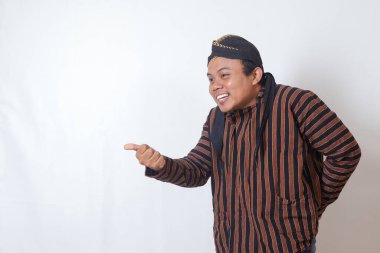 Cava kıyafetli, beyaz şapkalı, arkadaş canlısı Asyalı bir adamın portresi. En kibar şekilde birini davet ediyor. Beyaz arkaplanda izole edilmiş resim