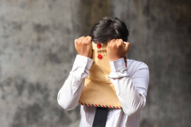 Beyaz gömlekli, içinde özgeçmişi olan kahverengi bir zarf taşıyan işsiz Asyalı bir adamın portresi. Personel alımı konsepti.