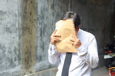 Beyaz gömlekli, içinde özgeçmişi olan kahverengi bir zarf taşıyan işsiz Asyalı bir adamın portresi. Personel alımı konsepti.