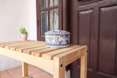 Porselenden yapılmış geleneksel bir kavanoz. Ahşap masanın üzerinde mavi desenli.