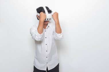 Sanal gerçeklik VR cihazı kullanan Asyalı bir adamın portresi, oyunda düşmanını yumruklamaya ve onunla savaşmaya çalışıyor. Beyaz arkaplanda izole edilmiş resim