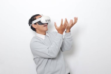 Sanal gerçeklik VR cihazı kullanan Asyalı bir adamın portresi, büyüleyici bir teknoloji deneyimliyor. Beyaz arkaplanda izole edilmiş resim