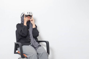 Sanal gerçeklik VR aygıtı kullanan, tesettürlü Asyalı kadın portresi. Beyaz arkaplanda izole edilmiş resim