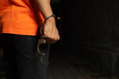 Suçlu şüpheli elleri kelepçeli olarak tutuklandı. Dramatik ışık portresi