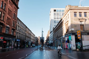 Glasgow İskoçya: 8 Ocak 2025: Sauchiehall Caddesi sakin bir kış sabahı şehir merkezinde alışveriş merkezleri, binalar ve gün boyunca açık mavi gökyüzü ile kalabalık bir şehir caddesi