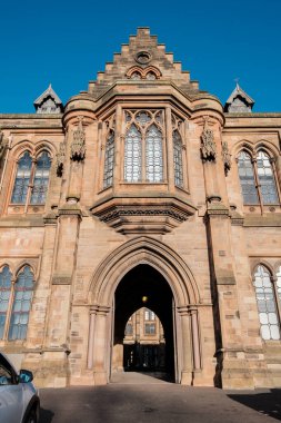 Glasgow İskoçya: 8 Ocak 2025: Glasgow Üniversitesi Gilmorehill. Gündüz vakti Glasgow 'da açık mavi gökyüzü altında bir üniversite binasının tarihi mimarisi