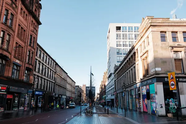 Glasgow İskoçya: 8 Ocak 2025: Sauchiehall Caddesi sakin bir kış sabahı şehir merkezinde alışveriş merkezleri, binalar ve gün boyunca açık mavi gökyüzü ile kalabalık bir şehir caddesi