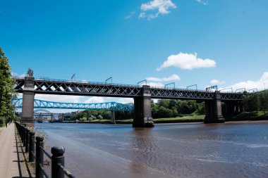 Newcastle UK: 28 Haziran 2024: Güneşli yaz gününde Newcastle Quayside. Kral VII. Edward Köprüsü Demiryolu Geçidi