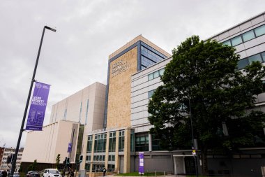 Leeds England: 3 Haziran 2024: Leeds Beckett Üniversitesi dış kampüsü. Ağaçlar ve üniversite işaretleriyle dış açılar geniş.